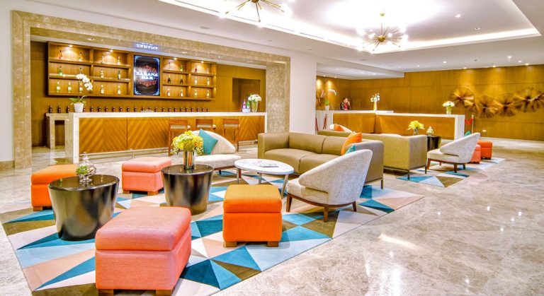 Handtufted carpet in teal and orange triangle pattern, hotel lobby