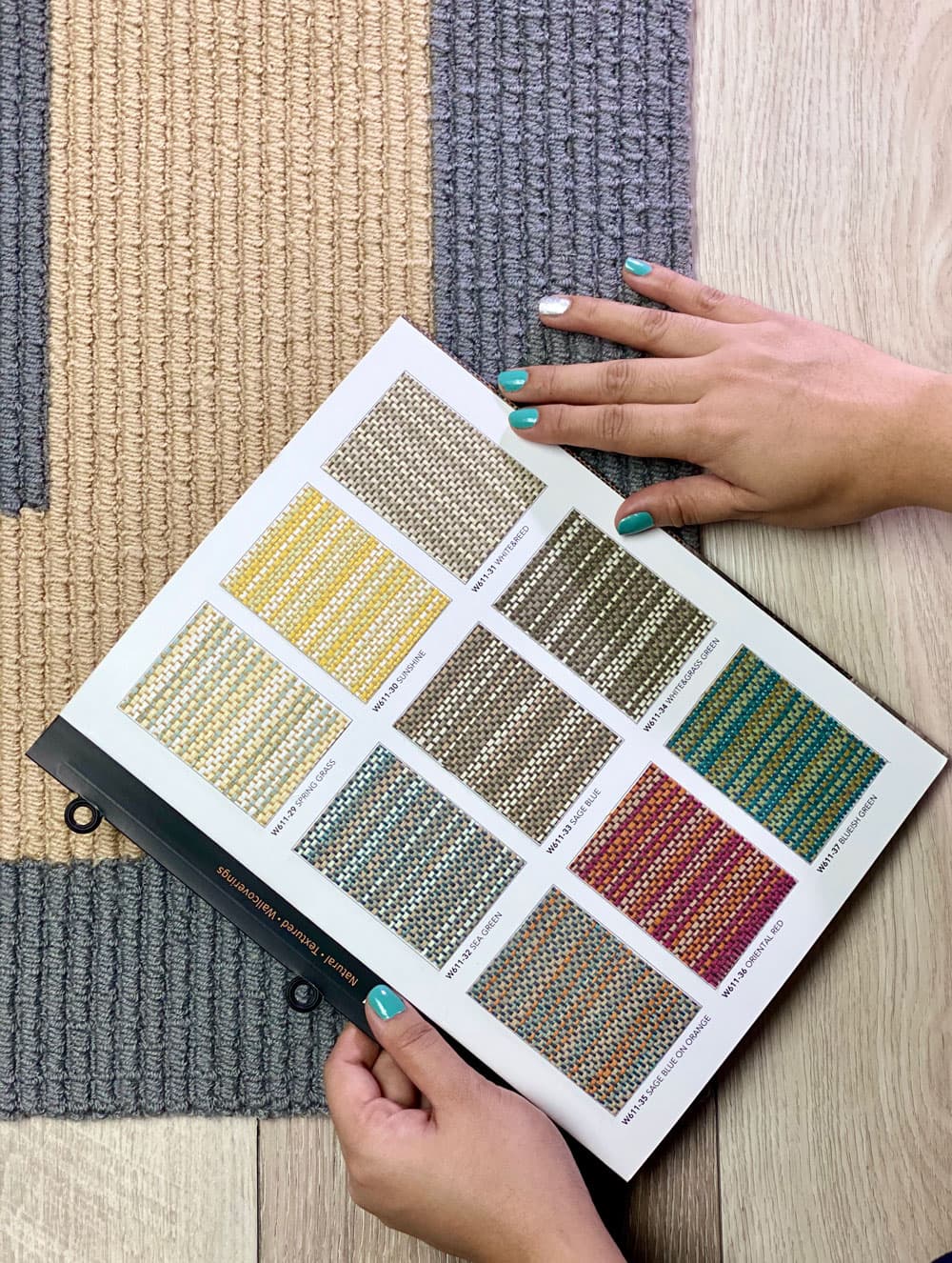 Carpet tile and broadloom sample book with color swatches on a wood floor