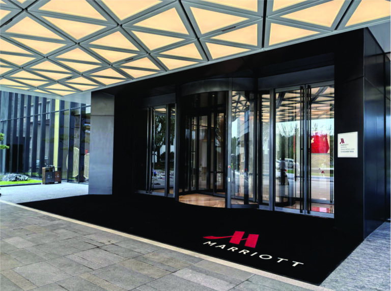 Custom logo entrance mat with hotel branding installed at a Marriott property entrance